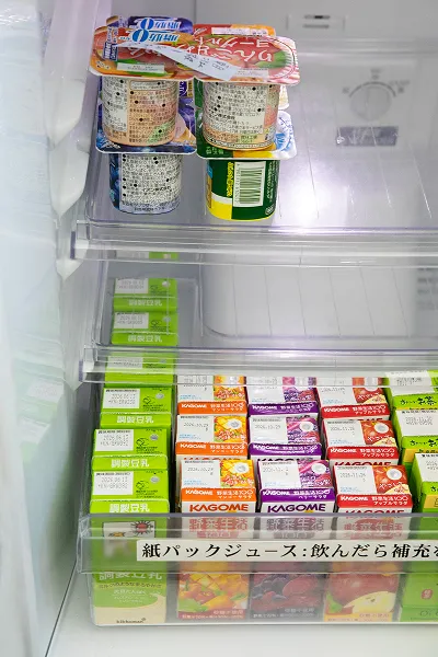 冷蔵庫内に整理整頓された紙パック飲料とヨーグルトカップ