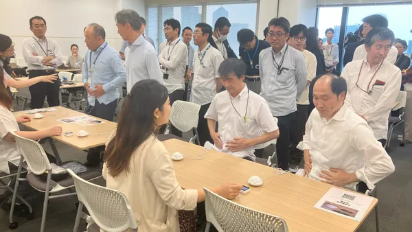 男性2人が椅子に座り生理痛の体験をしている様子