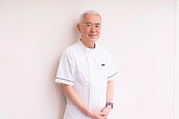 体の前で手を組みカメラ目線で笑顔の百枝幹雄さん